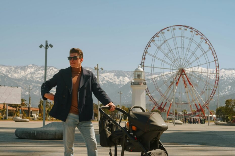 Nuna Triv Next travel system: A modern parent pushes the lightweight, compact stroller with integrated infant car seat through a city street, showcasing urban convenience.