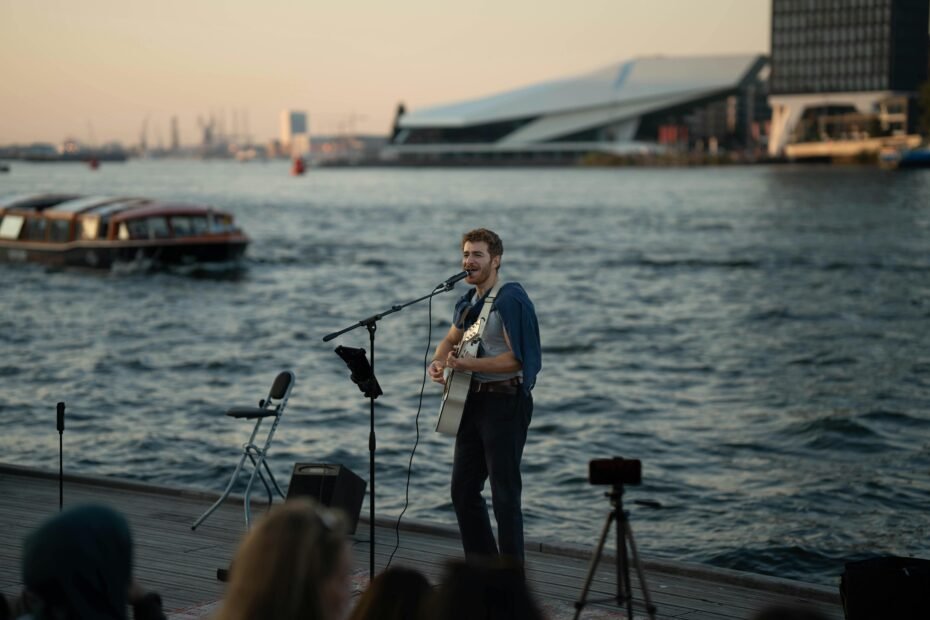 A musician passionately playing a compact travel bass guitar in a vibrant travel setting, illustrating the instrument's portability for global adventures and uninterrupted music practice.