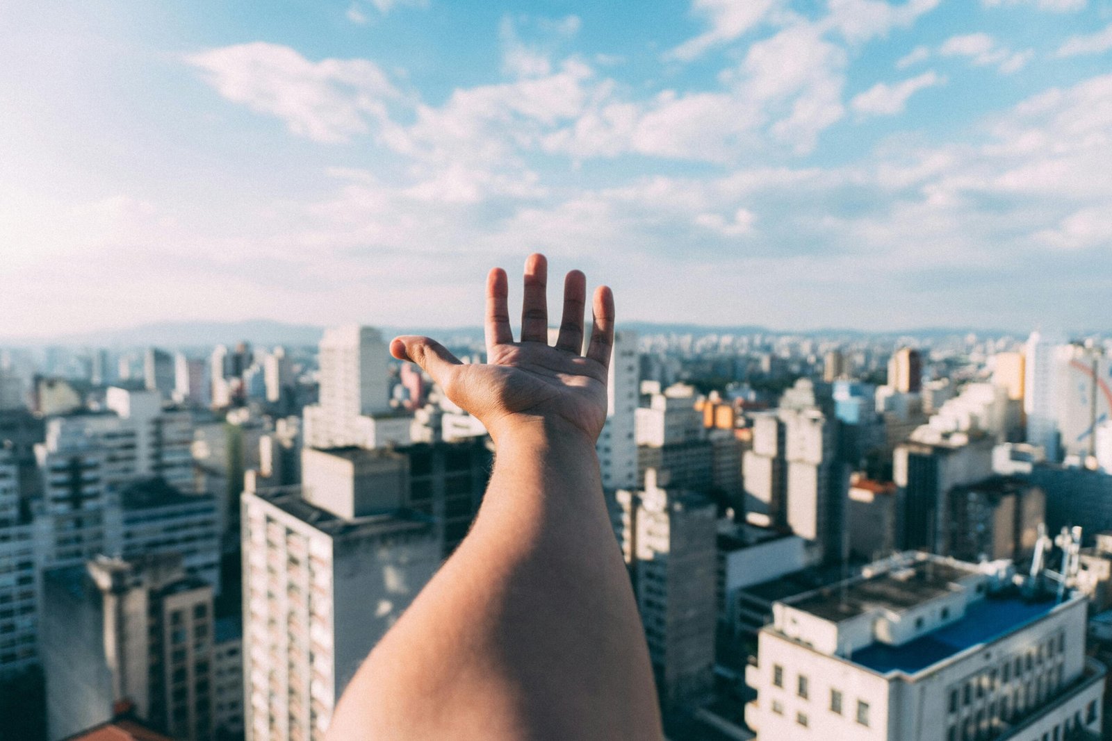 A confident Certified Nursing Assistant (CNA) smiling while looking at a vibrant city skyline, representing the flexibility and adventure of a 4-week travel contract with housing.