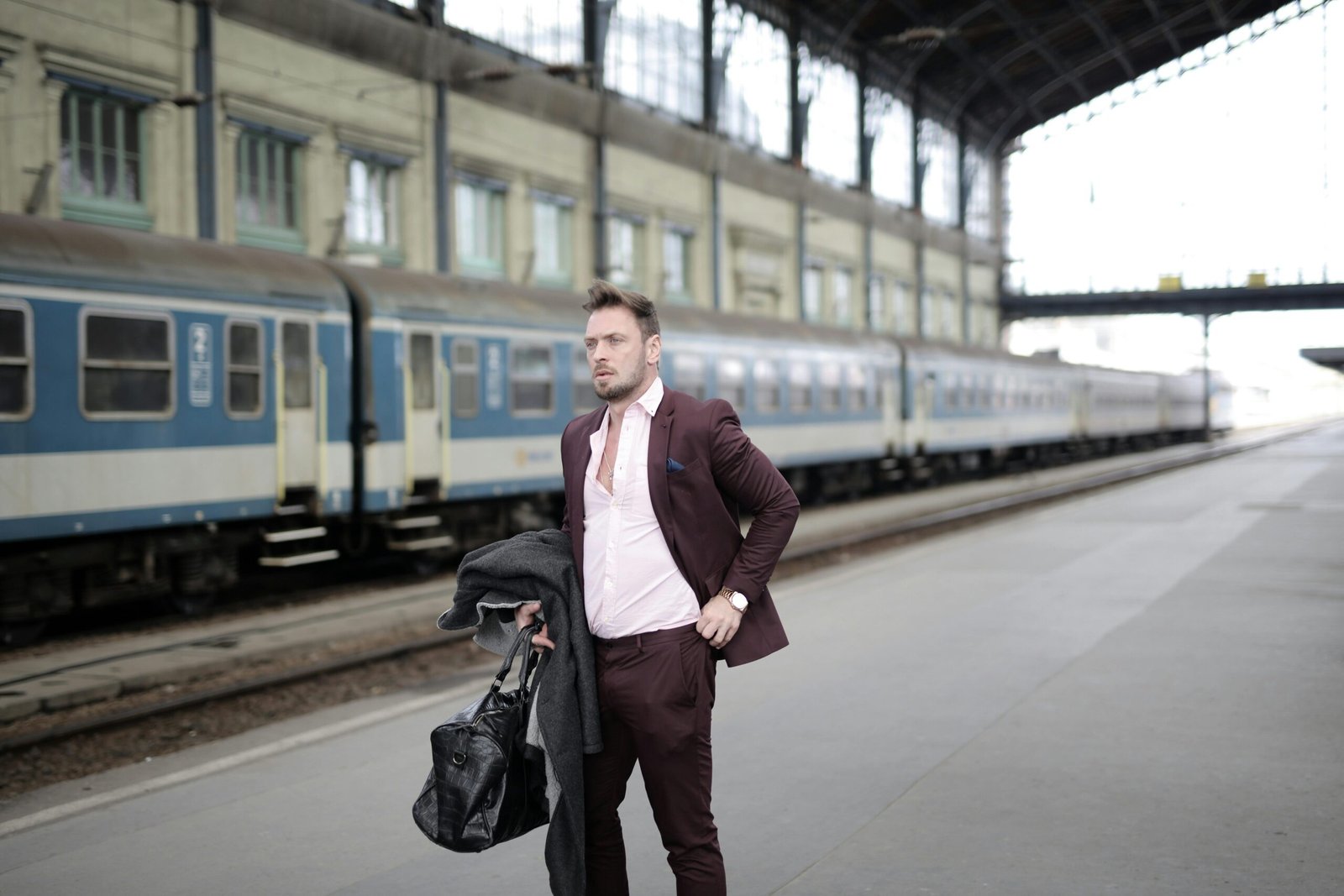 Professional business traveler carrying a premium travel suit bag through an airport terminal, ensuring a wrinkle-free suit for a confident first impression.