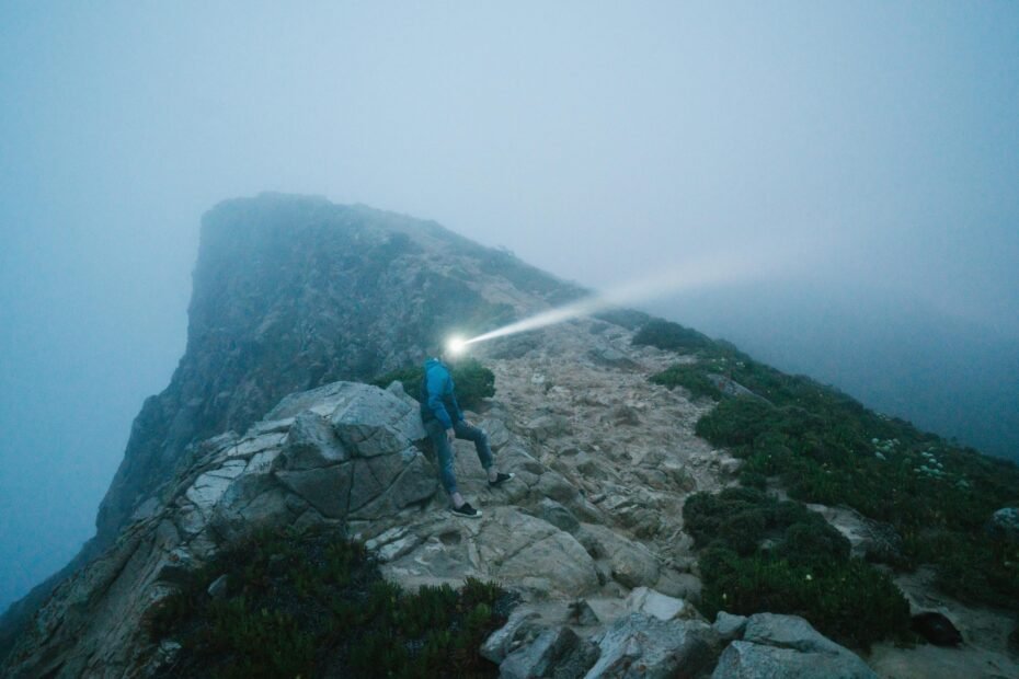 Beautiful moonstone crystal, the ultimate traveler's stone, held in a hand against a scenic travel backdrop, symbolizing protection, guidance, and good fortune for adventurers on their journey.