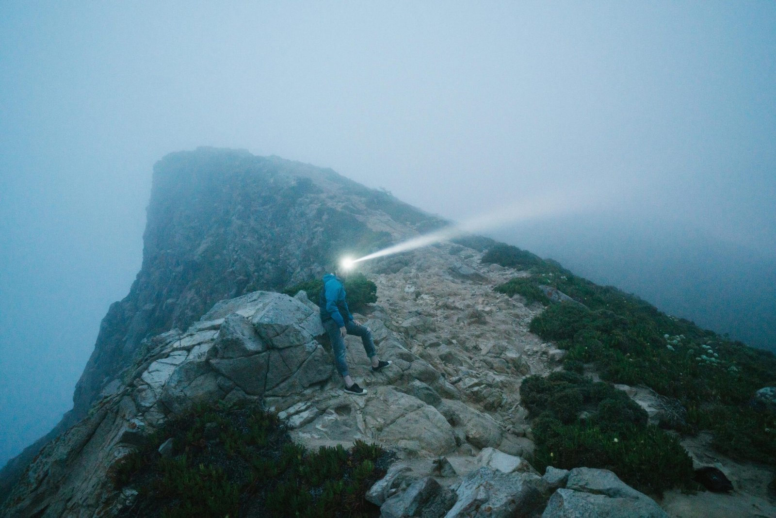 Beautiful moonstone crystal, the ultimate traveler's stone, held in a hand against a scenic travel backdrop, symbolizing protection, guidance, and good fortune for adventurers on their journey.