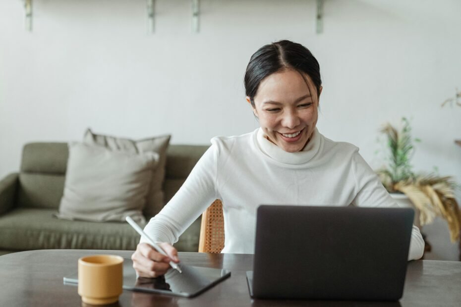 Remote nurse working from home on a laptop in a bright, modern setting, illustrating the flexibility and work-life balance of telehealth and remote nursing jobs.
