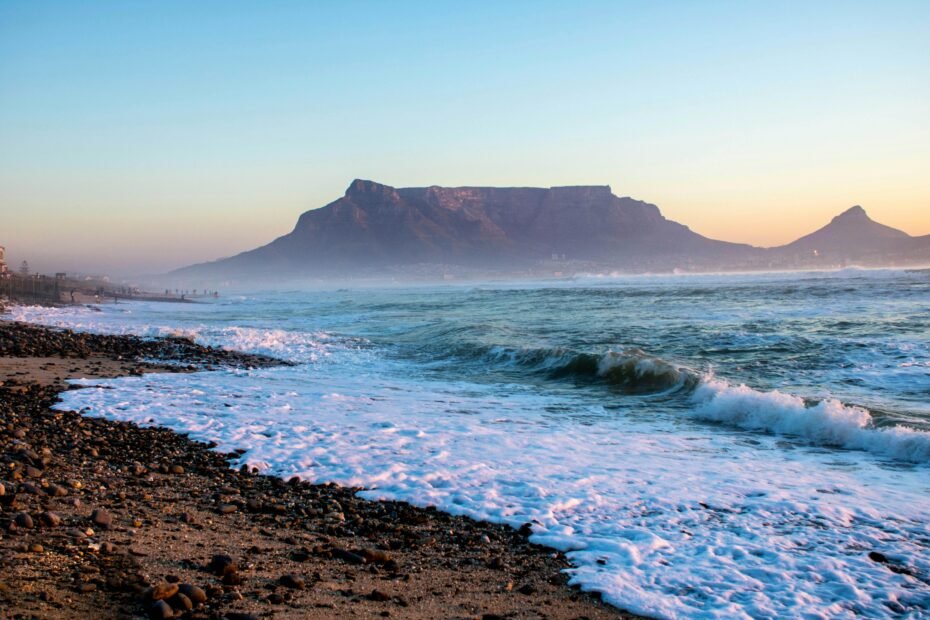 Panoramic view of Cape Town, South Africa, featuring iconic Table Mountain, the vibrant cityscape, and the beautiful Atlantic Ocean coastline, illustrating the best time to travel to this top destination.
