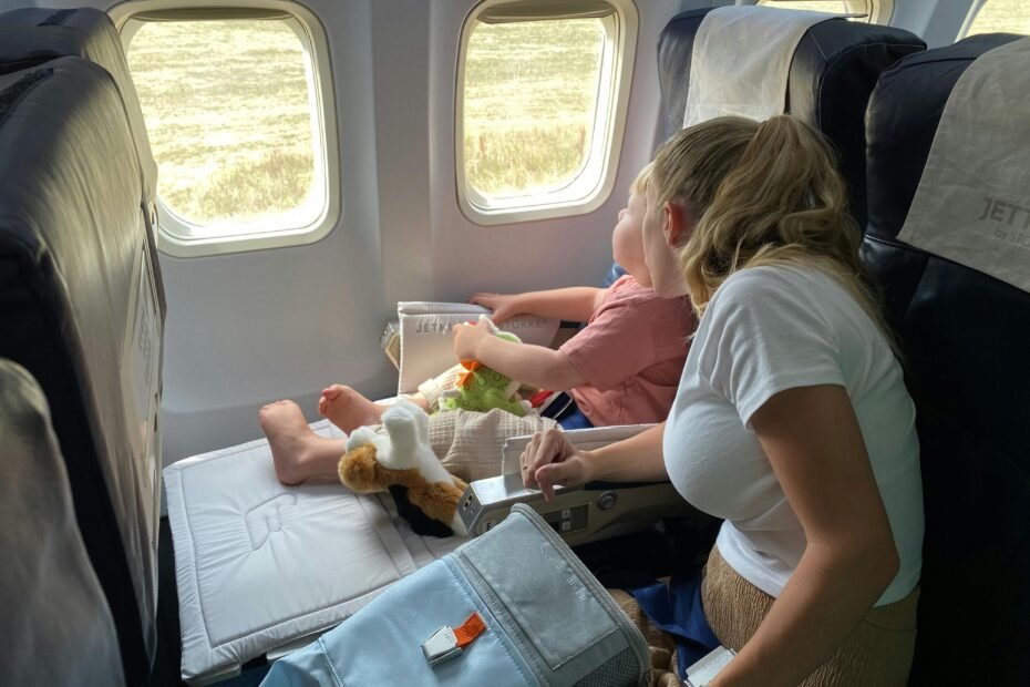 Young child safely secured in an FAA approved travel car seat on an airplane, providing comfort and safety for family air travel.