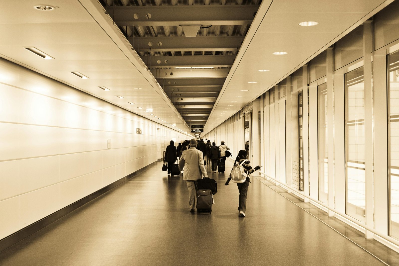 Parents wheeling a Nuna travel bag with a baby stroller through an airport terminal, illustrating secure and stress-free family travel with protected baby gear.