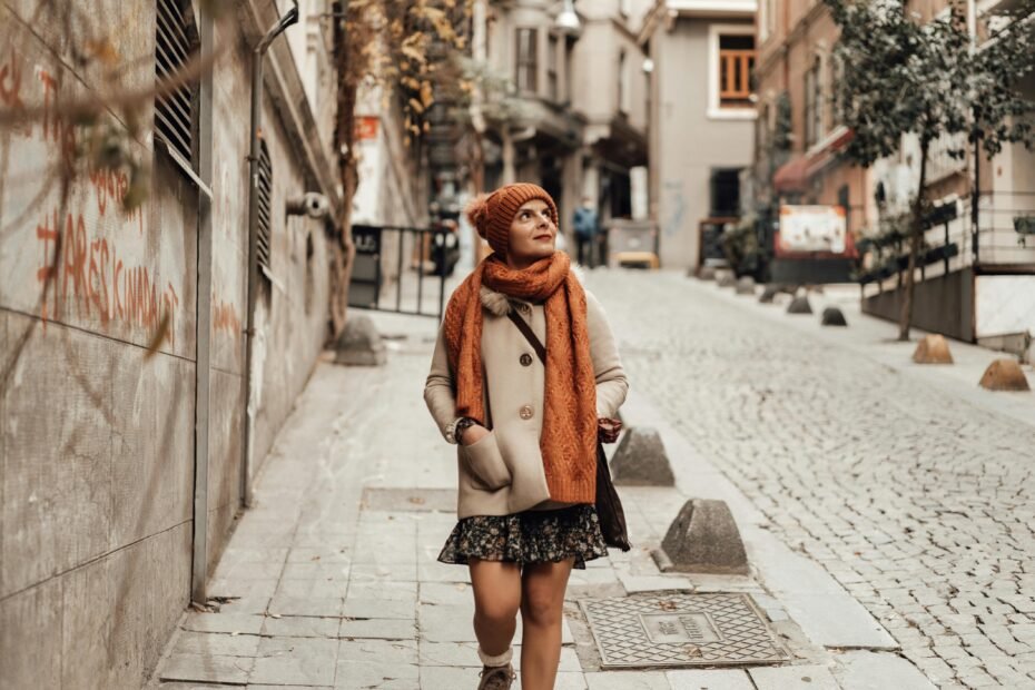 Stylish woman in a comfortable, versatile travel outfit walking on a European cobblestone street, perfect for exploring cities.