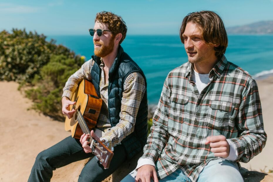 Musician playing a compact travel guitar in a beautiful outdoor landscape, symbolizing freedom and music on any adventure.