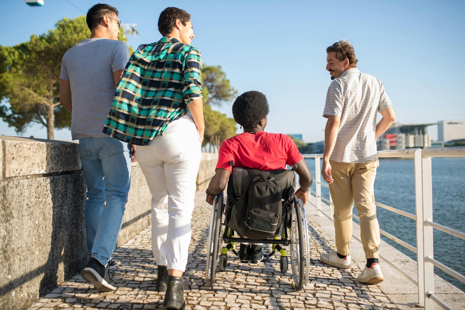 A diverse group of smiling travelers, including a person in a wheelchair and a senior, enjoying a universally accessible tourist destination, illustrating the benefits of a universal travel agent and inclusive tourism.