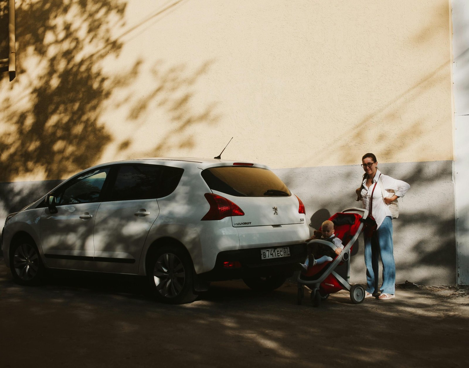 Maxi Cosi Tayla Travel System: A parent pushing a modern baby stroller with an infant car seat, highlighting convenient and stylish family travel.