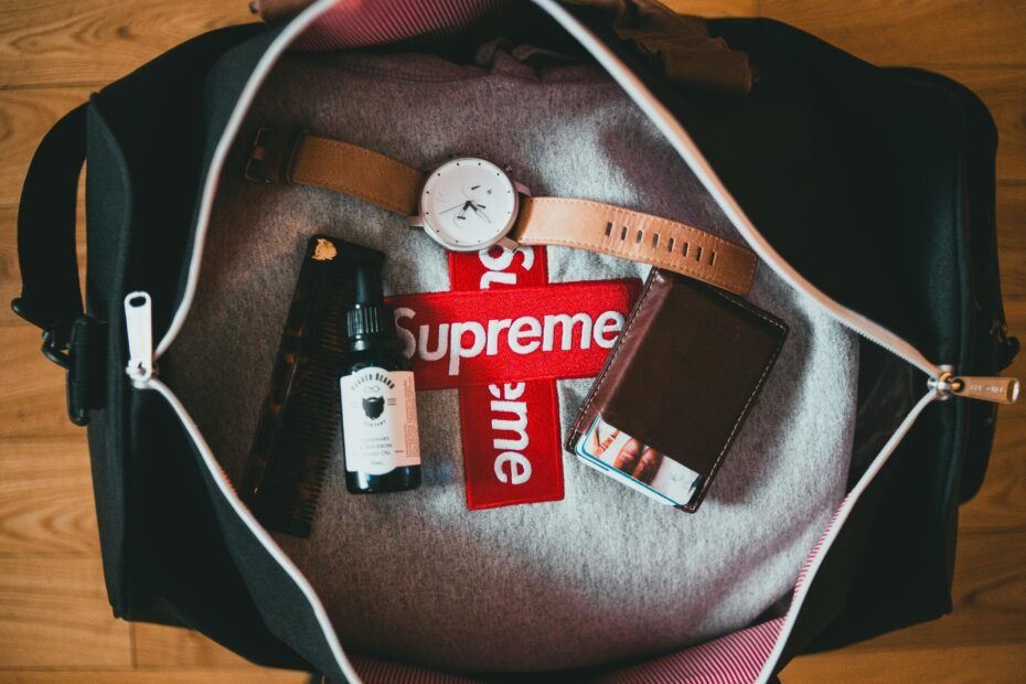 A flat lay image displaying a meticulously organized collection of modern travel essentials for a smart packing list, including a portable charger, noise-canceling headphones, packing cubes, a reusable water bottle, and a compact first-aid kit, all arranged to signify preparedness for a smooth journey.