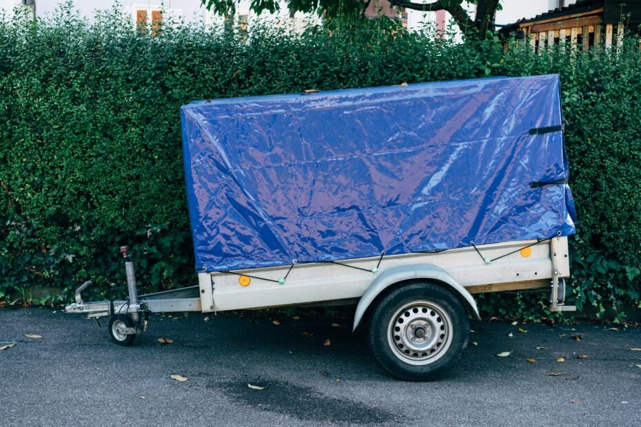 Protective heavy-duty air conditioner cover securely installed on the rooftop AC unit of a white travel trailer, ensuring longevity and weather protection.