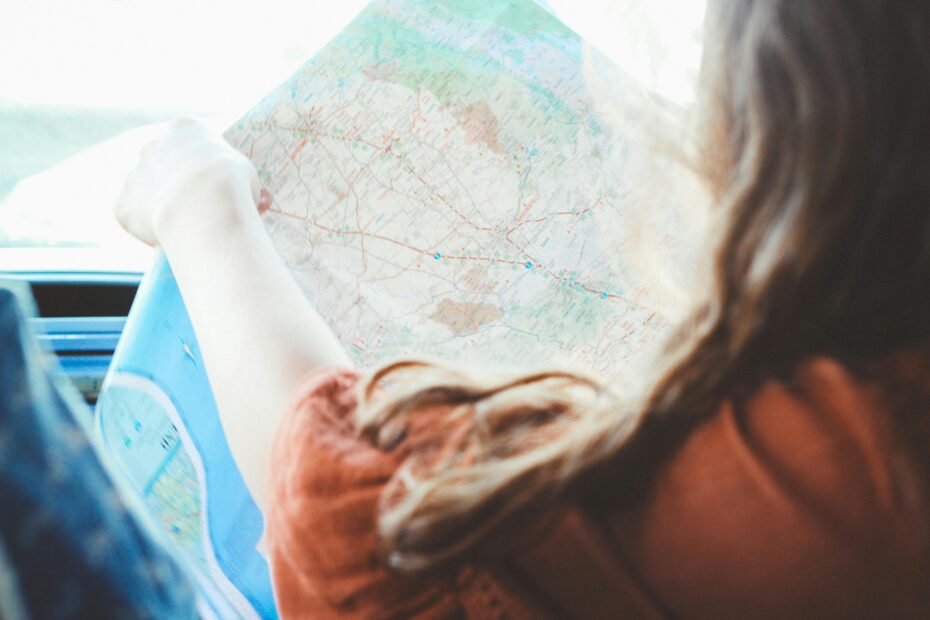 Young person planning a meaningful travel journey with a world map and laptop, symbolizing the dream of studying abroad, volunteering, or interning, made possible by crowdfunding platforms like Fund My Travel.