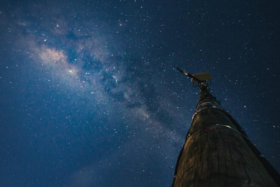 Vibrant illustration depicting radio waves, part of the electromagnetic spectrum, propagating at the speed of light through the dark vacuum of space, perhaps originating from a distant satellite, emphasizing cosmic communication and the universal speed limit.