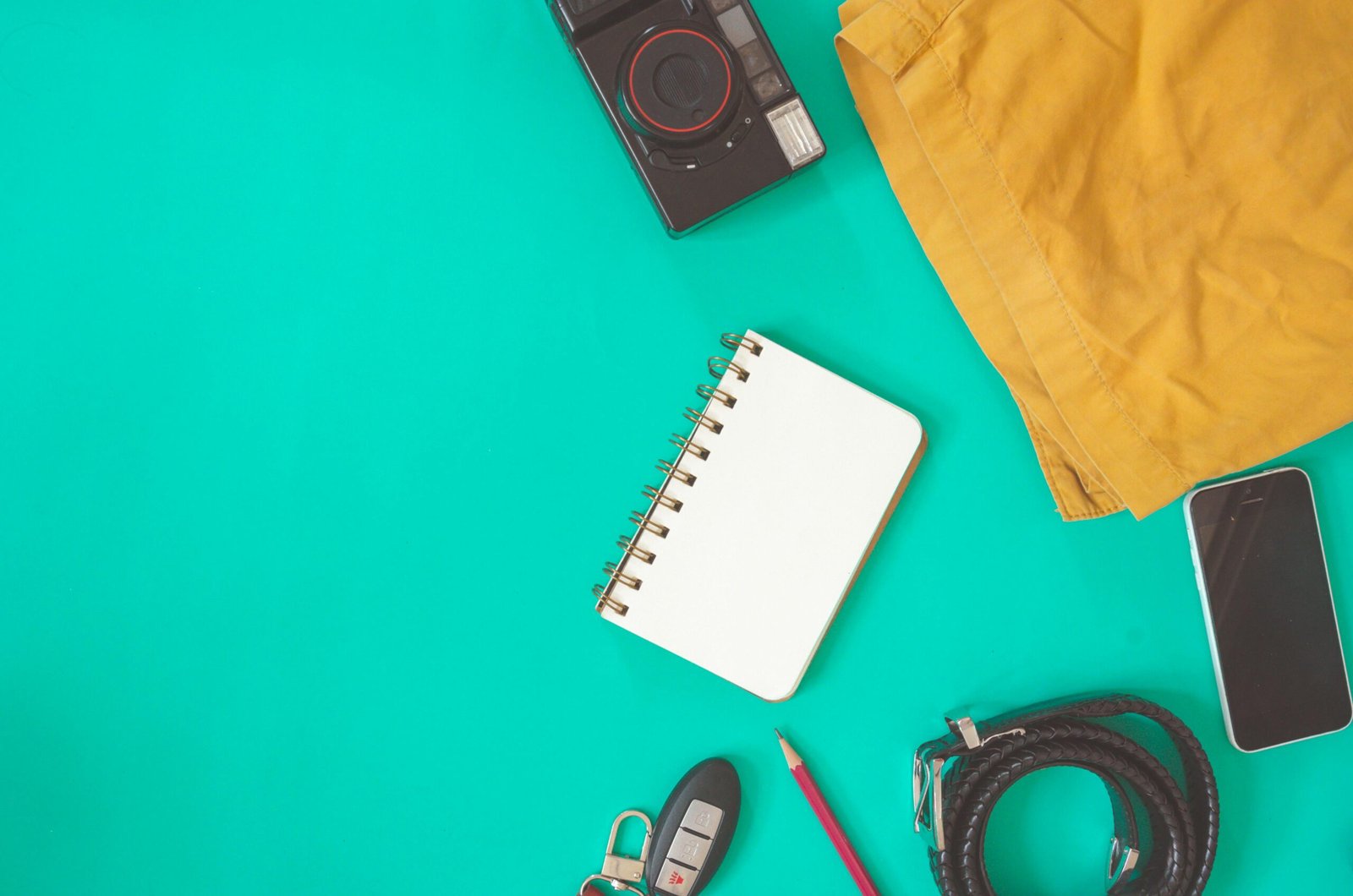 A small blue-lidded pot of travel-size Vaseline positioned among minimalist travel essentials in a suitcase, representing efficient packing and multi-purpose use for savvy travelers.