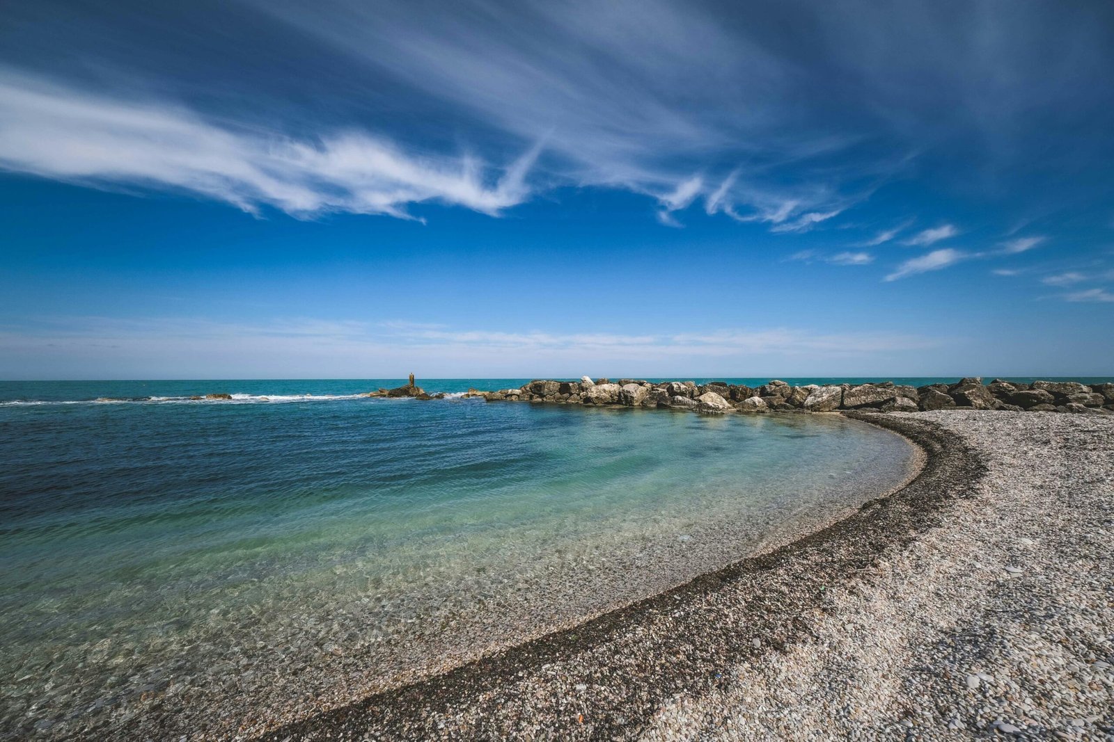 Idyllic Barbados beach scene with crystal-clear turquoise waters, white sand, and palm trees under a sunny sky, illustrating the best time for a Caribbean vacation.