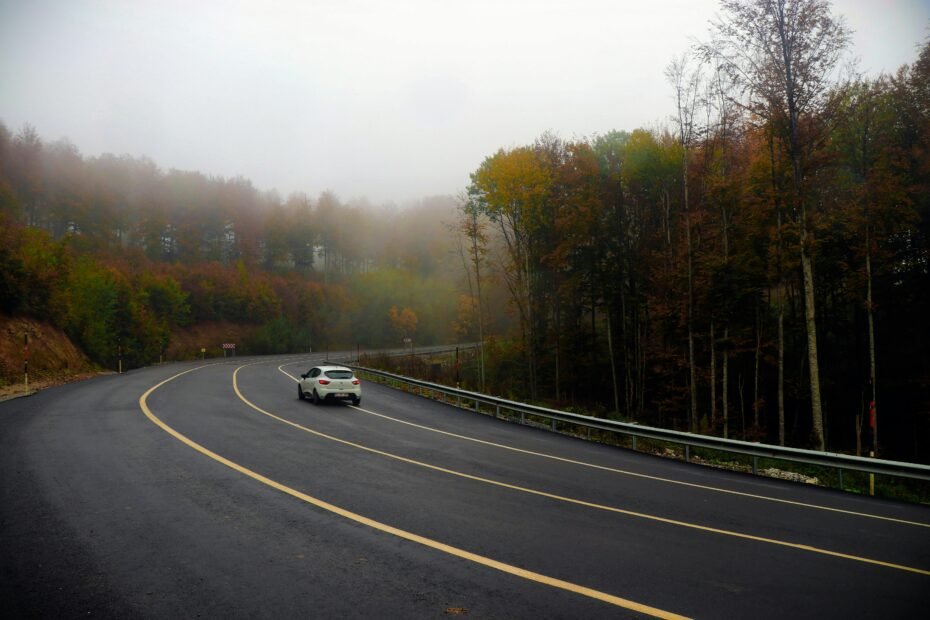 A scenic view of an Oregon highway winding through mountains with changing weather, symbolizing safe trip planning using Oregon travel cams to check real-time road conditions and ensure a smooth journey.
