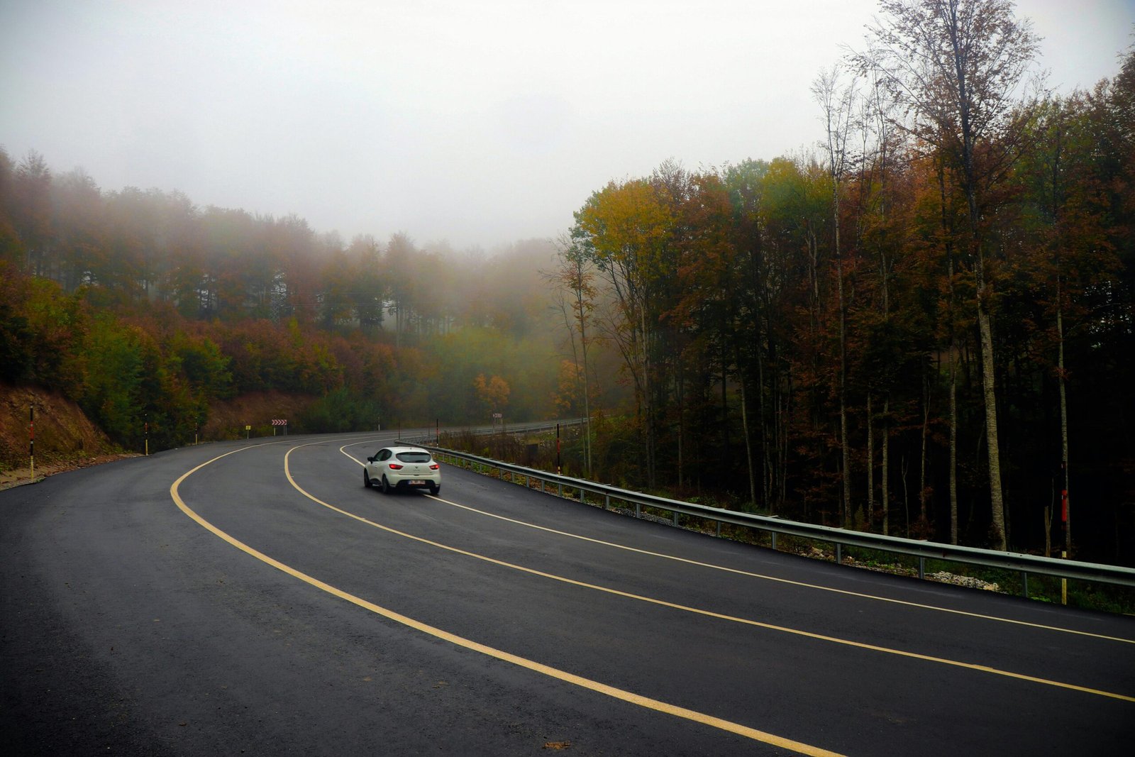 A scenic view of an Oregon highway winding through mountains with changing weather, symbolizing safe trip planning using Oregon travel cams to check real-time road conditions and ensure a smooth journey.