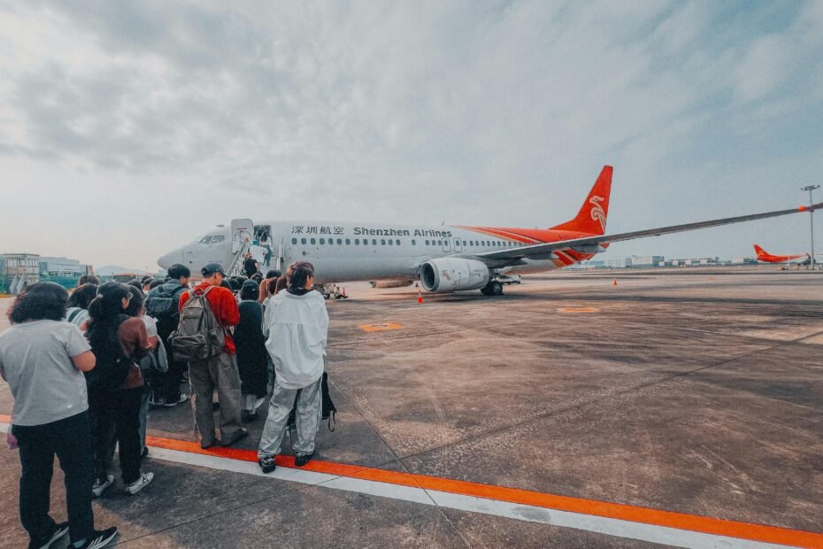 TFO Traveler Carry On luggage for fly fishing, showing an angler easily navigating an airport terminal with integrated rod and reel protection for travel.