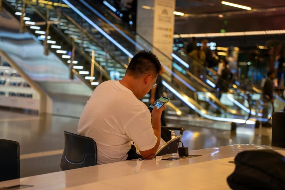 Traveler with carry-on luggage waiting at an airport gate, looking at a flight departure board, symbolizing the uncertainty and excitement of non-rev standby travel for airline employees.