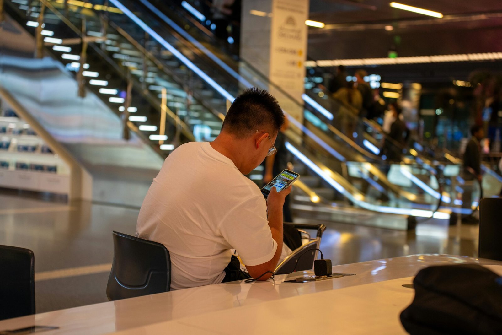 Traveler with carry-on luggage waiting at an airport gate, looking at a flight departure board, symbolizing the uncertainty and excitement of non-rev standby travel for airline employees.
