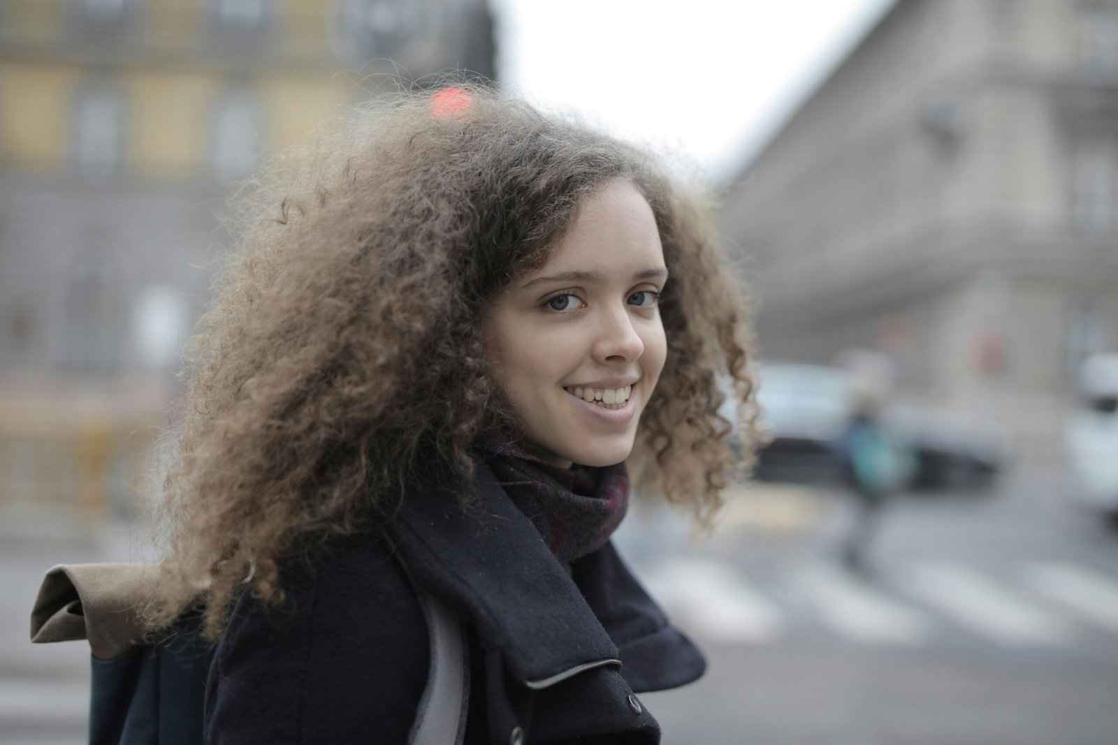 Woman confidently exploring a vibrant city street with a stylish and secure hands-free crossbody bag, ideal for travel and offering comfort and accessibility.