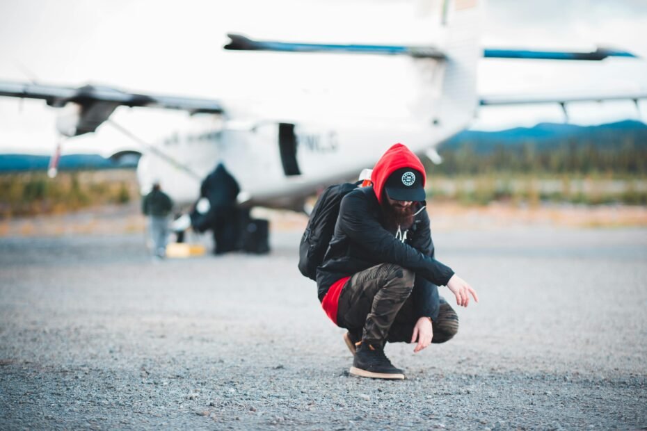 A person in a hoodie and sunglasses discreetly walking through a private airport terminal, illustrating celebrity travel tactics for privacy and avoiding public attention.