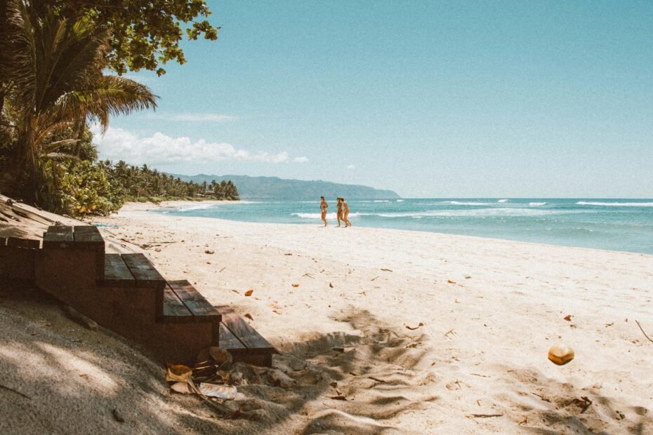 Happy couple enjoying a luxurious Hawaiian beach vacation with Aloha Travel, featuring pristine turquoise waters and palm trees.