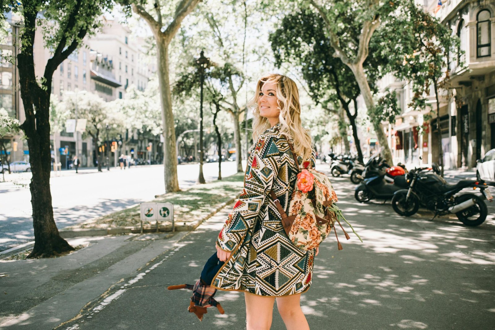 A stylish female traveler confidently walking with a comfortable and ergonomic ladies travel backpack in an urban setting, emphasizing the best travel backpacks for women.