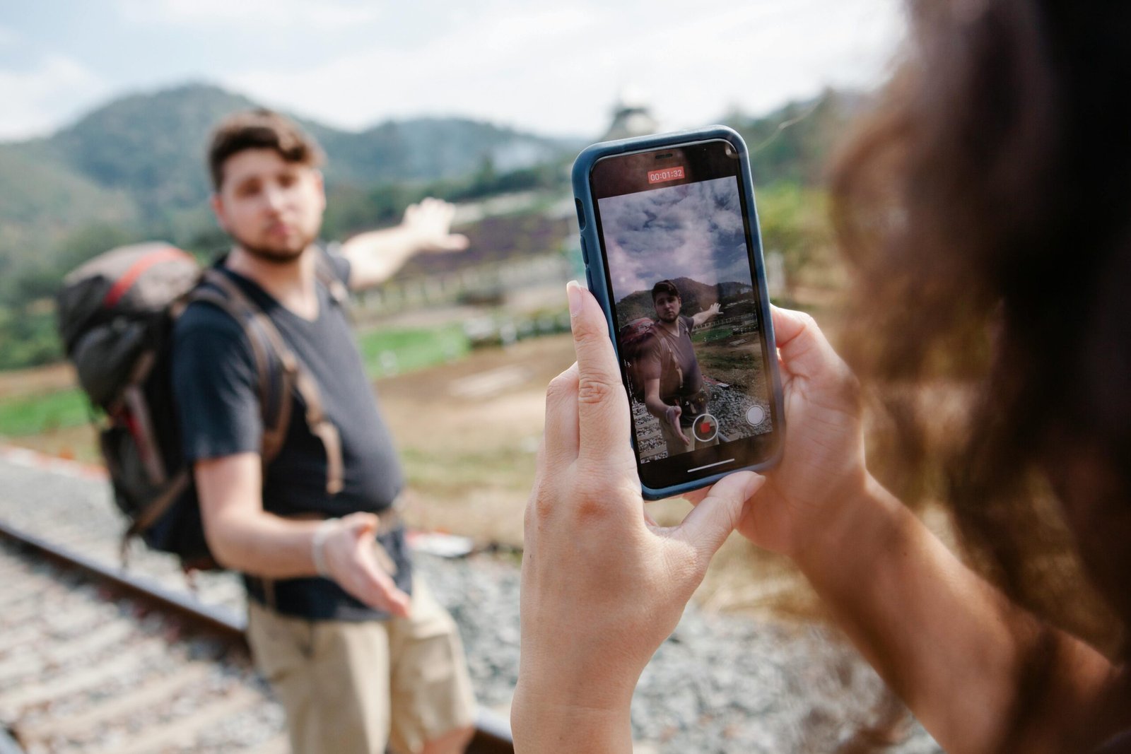 Person filming a scenic travel video with a smartphone and gimbal, capturing dynamic footage for social media and sharing travel adventures.