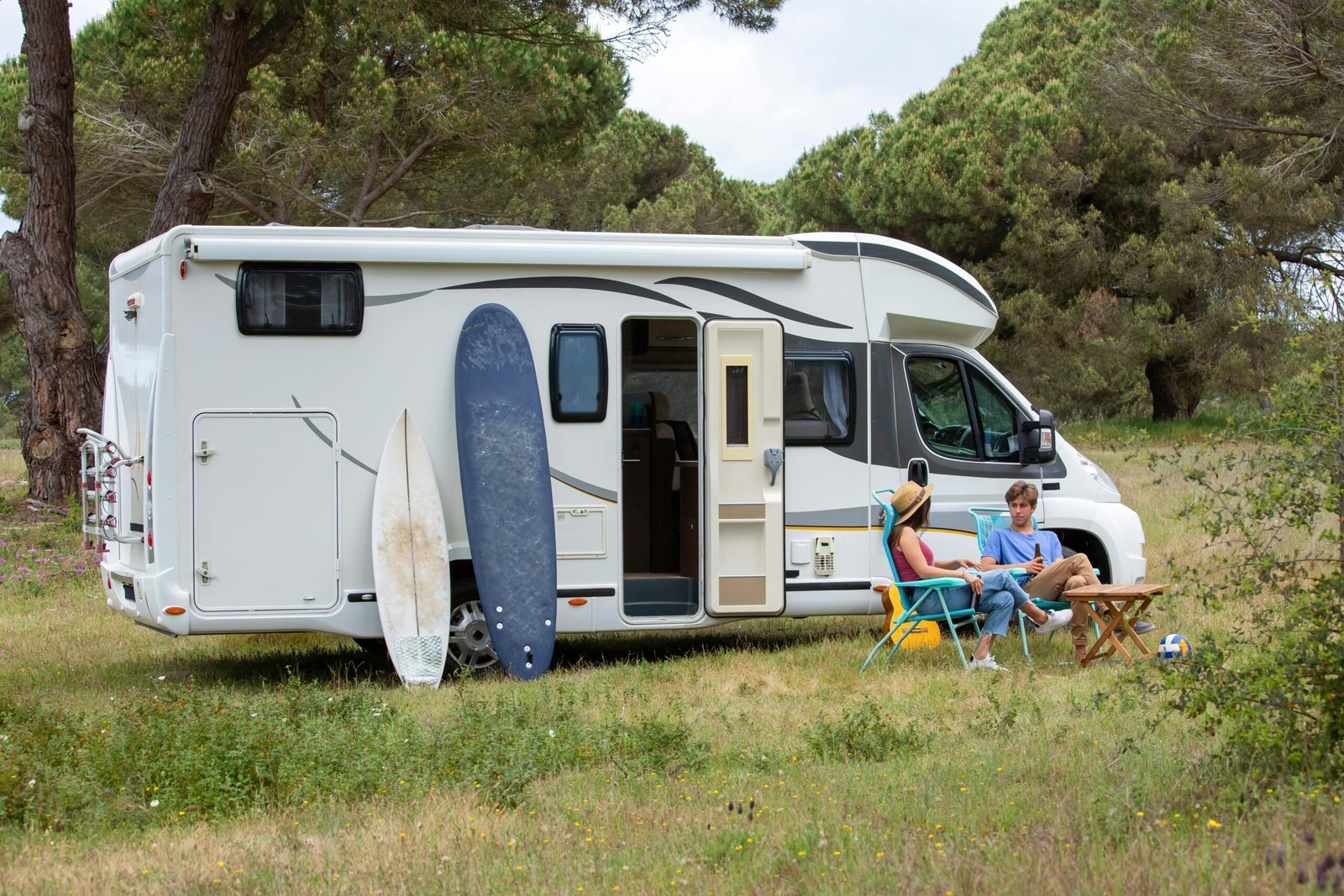 Modern Keystone travel trailer RV parked in a beautiful scenic campsite, with a family enjoying outdoor activities, highlighting quality, comfort, and adventure for future travels.
