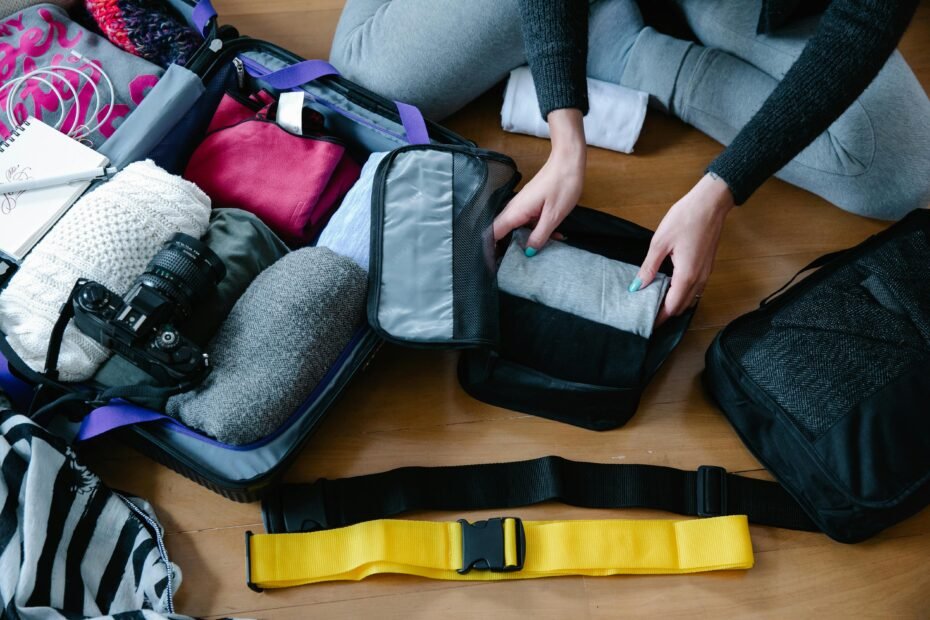 Traveler efficiently packing a suitcase using a hand pump to compress clothes in a travel vacuum bag, showcasing smart space-saving and organization.