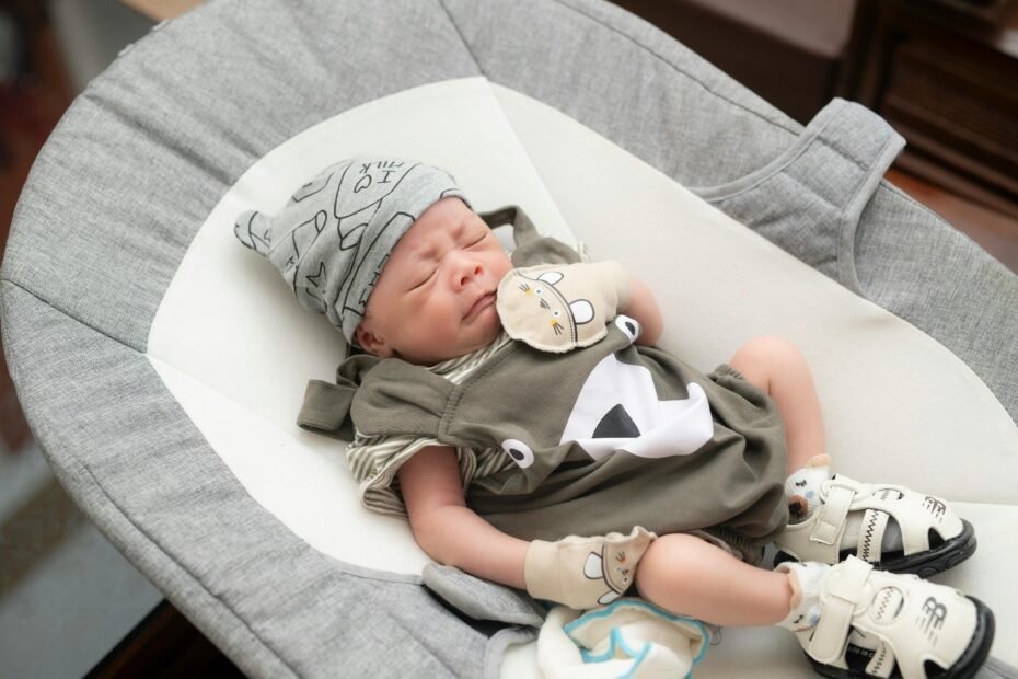 Happy baby sleeping soundly in a modern, portable travel bassinet, emphasizing safe and comfortable sleep solutions for families on the go. Ideal for reviewing the best travel bassinets.