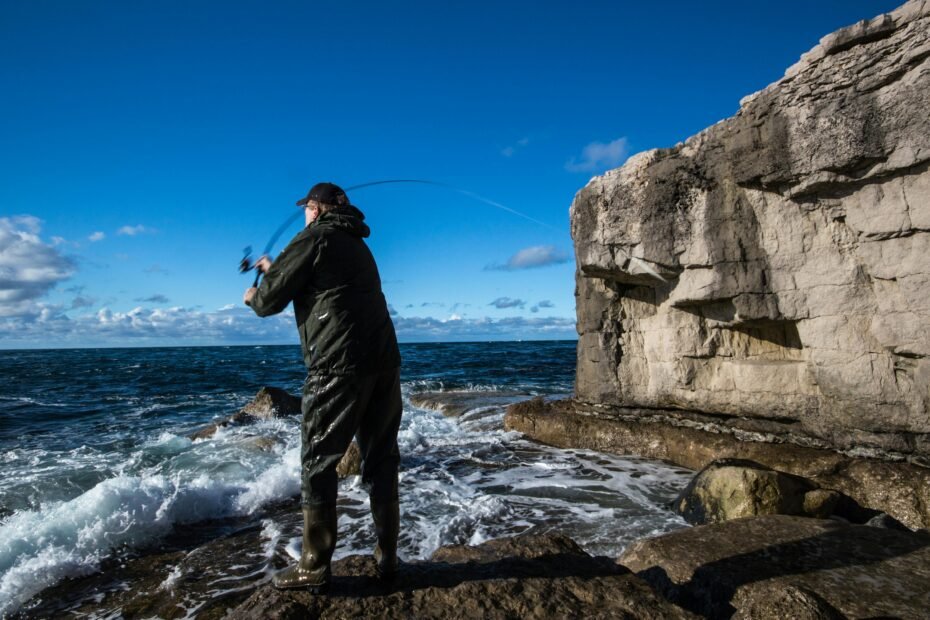 An angler on a scenic travel destination, holding a compact multi-piece traveling fishing rod, ready for a portable fishing adventure.